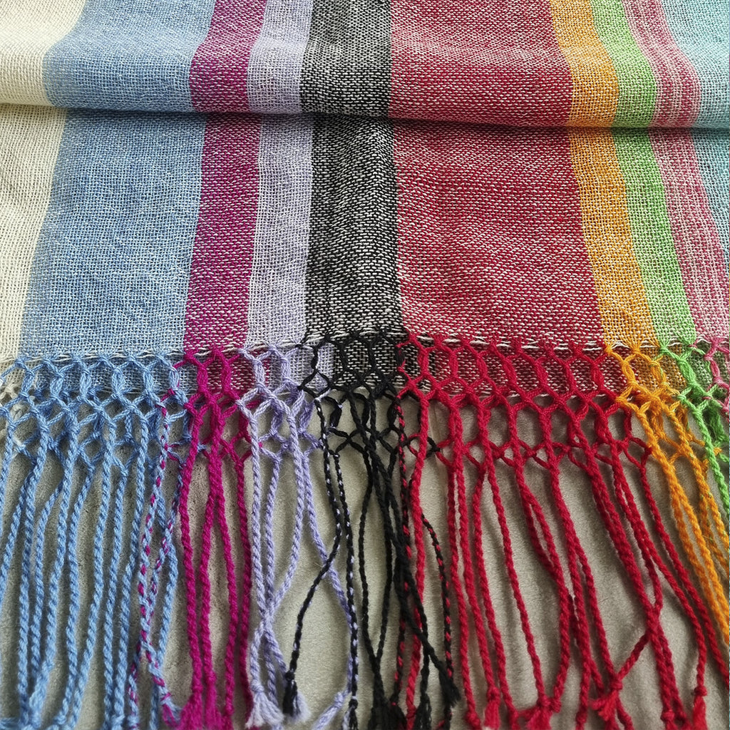 Multicolor striped wool wrap worn over the shoulders outdoors
